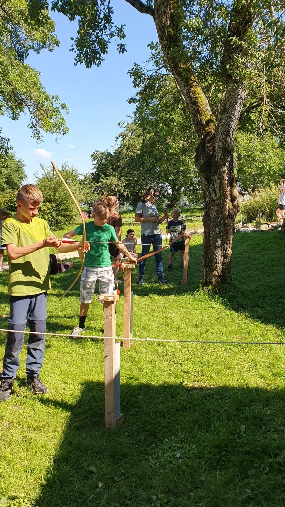 `Kinder beim Bogenschiessen im Freien, Wildniskurs Dakawo Schweiz`