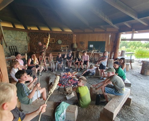 `Kinder grillen Brot am Feuer in der Naturhütte, Abenteuerlager Dakawo Schweiz`